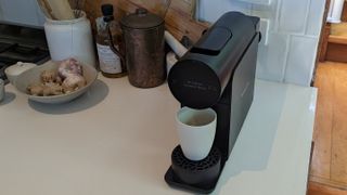 The Morning Machine on a kitchen countertop with a white cup under the spout
