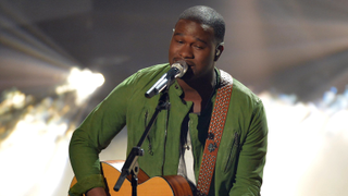 American Idol contestant CJ Harris performing with a guitar.