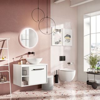 a large bathroom with pink and white walls and accessories, with a pink splatter pattern terrazo floor and the toilet and undersink cabinet both fastened to the wall