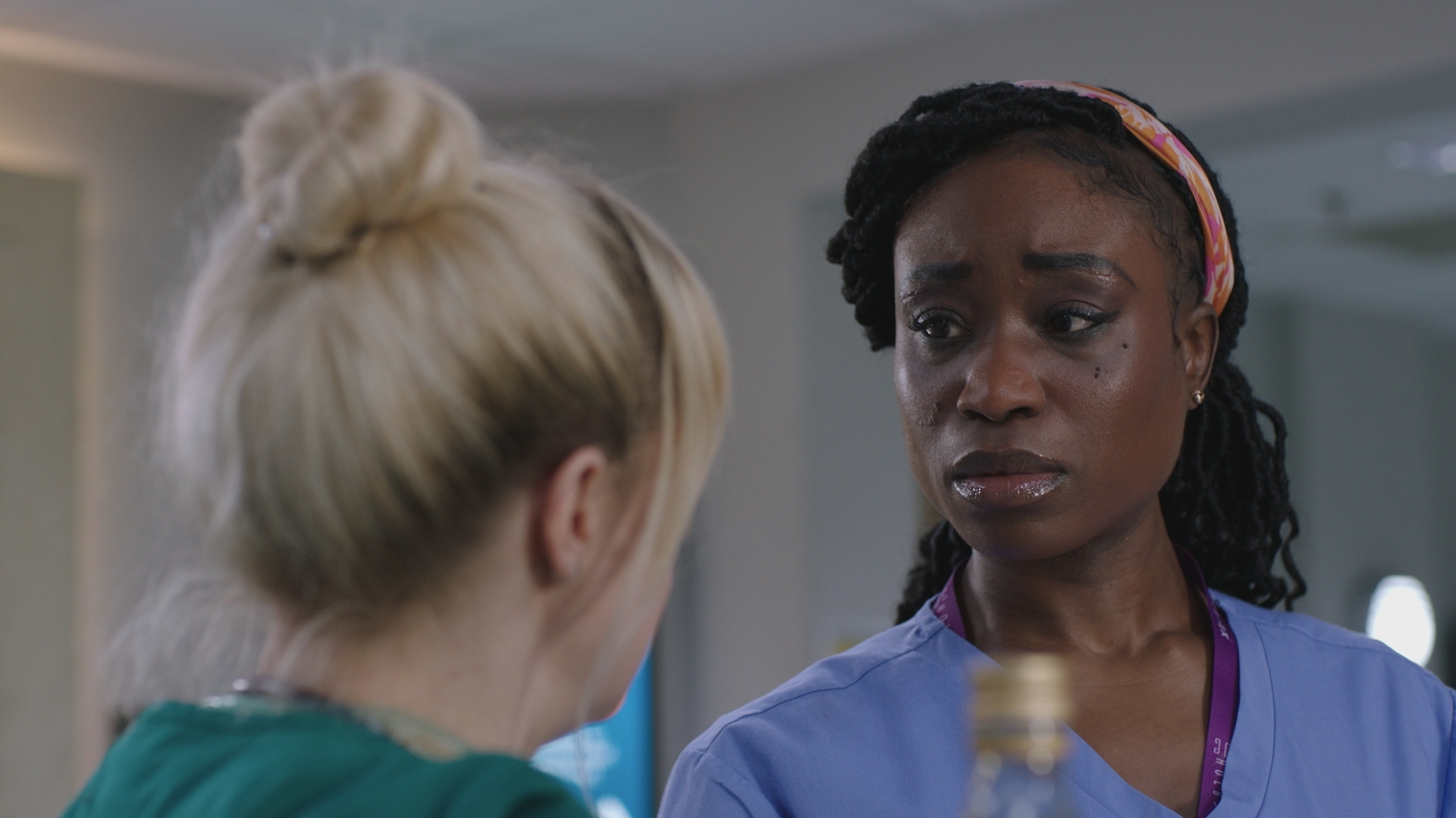 Ngozi looking sad while talking to Nicole at work.