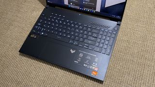 Asus TUF A16 laptop keyboard on a beige rug