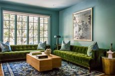 a blue living room with green sofas
