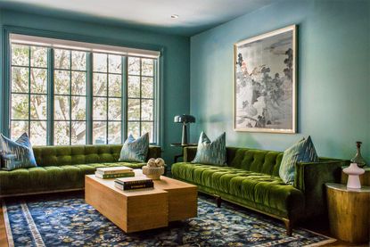 a blue living room with green sofas