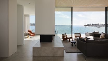 open plan living dining room with concrete floor and sea views