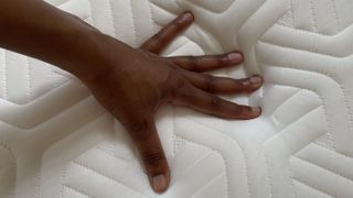 Our lead reviewer places her hand on the Tempur Hybrid Elite Mattress during a temperature regulation test