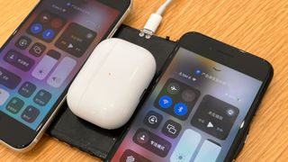 A prototype of Apple's abandoned AirPower wireless charging mat, with several devices charging on top of it.