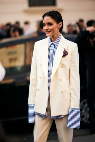 Olivia Palermo wears an oversize stripe shirt under a cream blazer at Milan Fashion Week