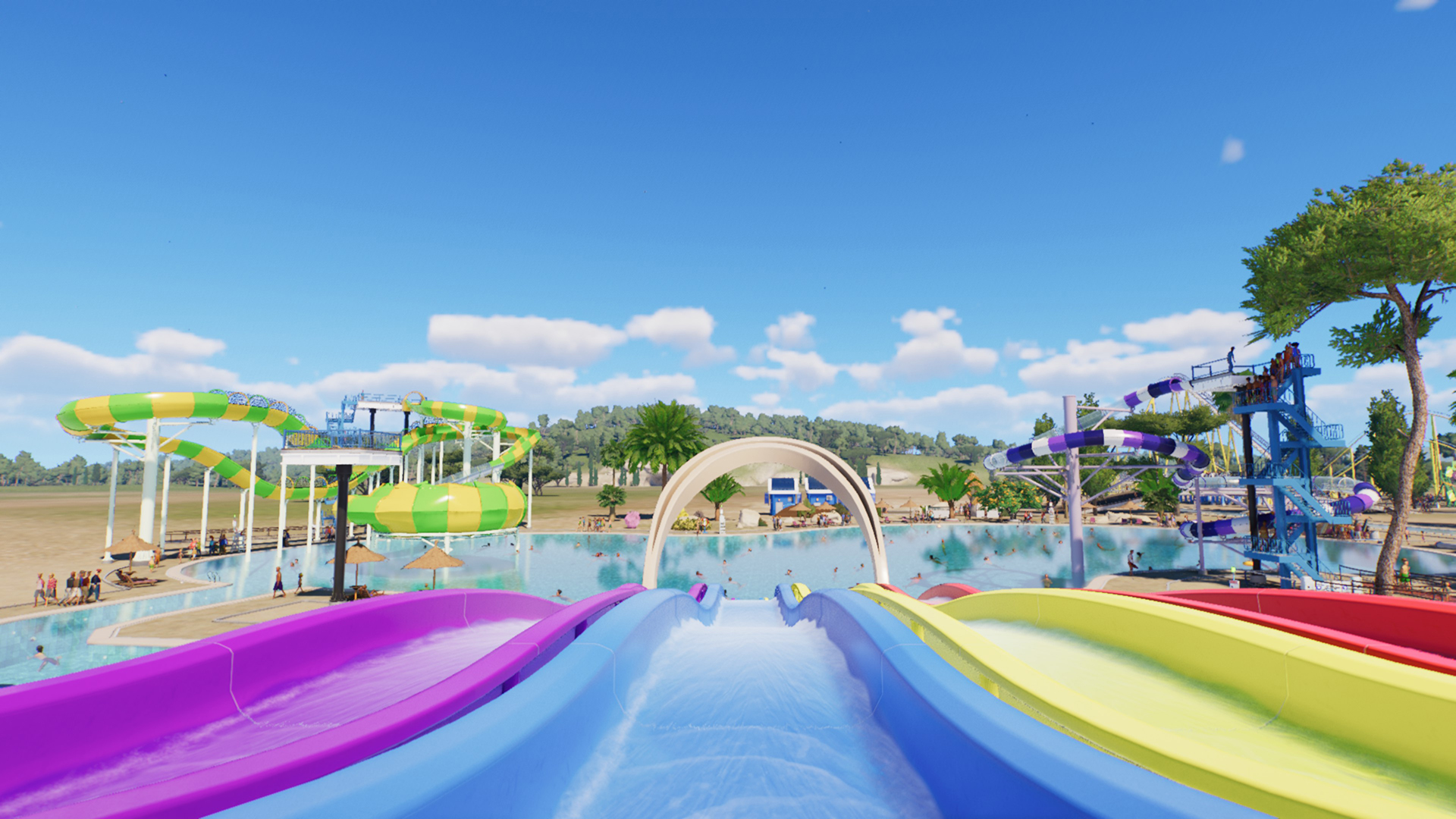 A rainbow-colored waterslide leading into a pool.