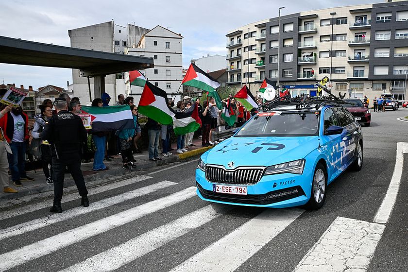 Pro-Palestinian protesters wave flags and shout as Team Israel Premier Tech&#039;s team car drives by in Poio at the start of the 16th stage of the Vuelta a Espana, a 172 km race between Poio and Castro de Herville, on September 9, 2025. (Photo by Miguel RIOPA / AFP)