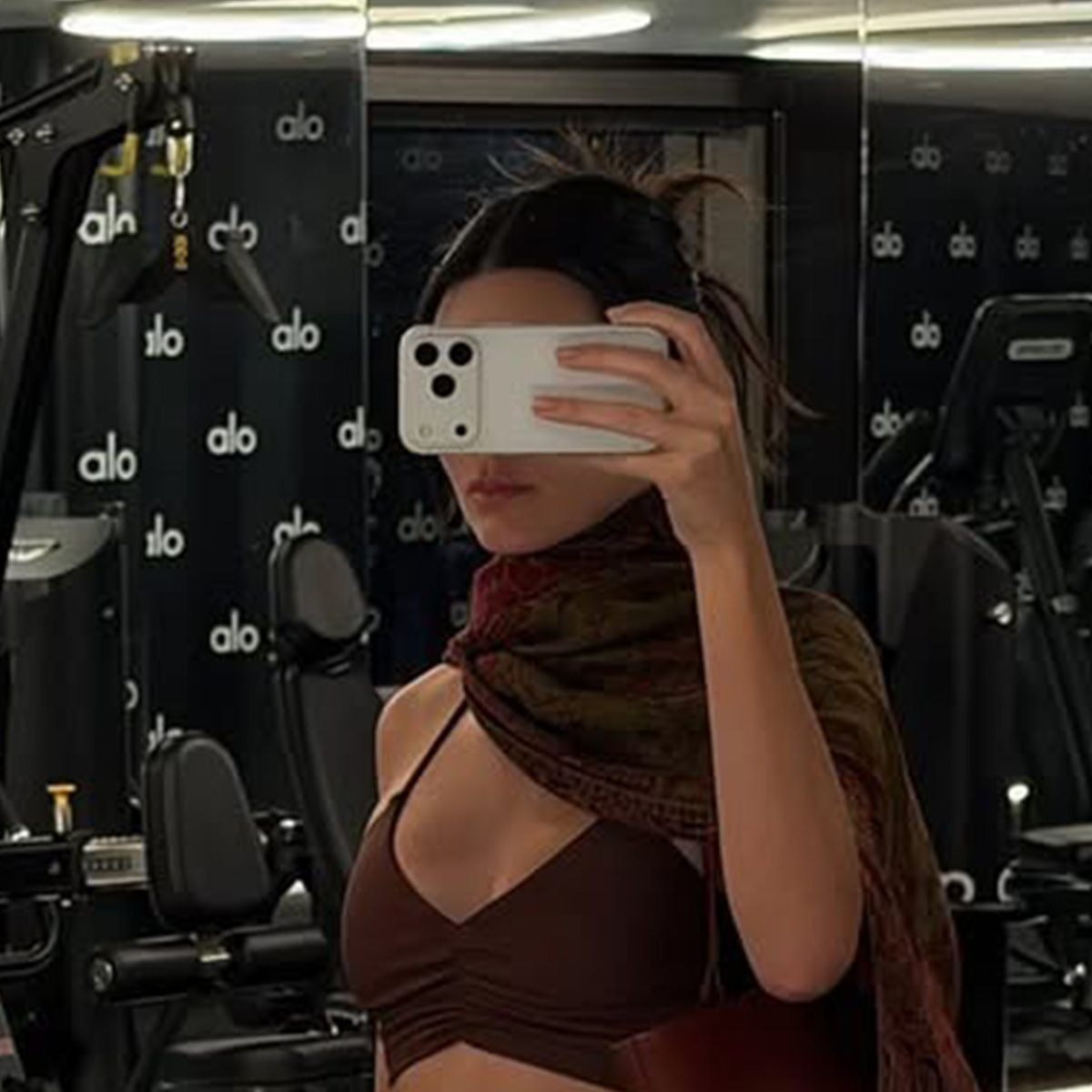 kendall wears a brown scarf and brown sports bra.