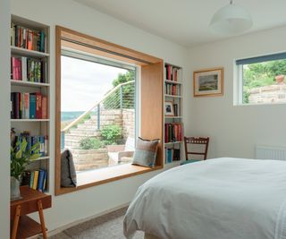 large and deep picture window with bookshelves recessed in walls either side