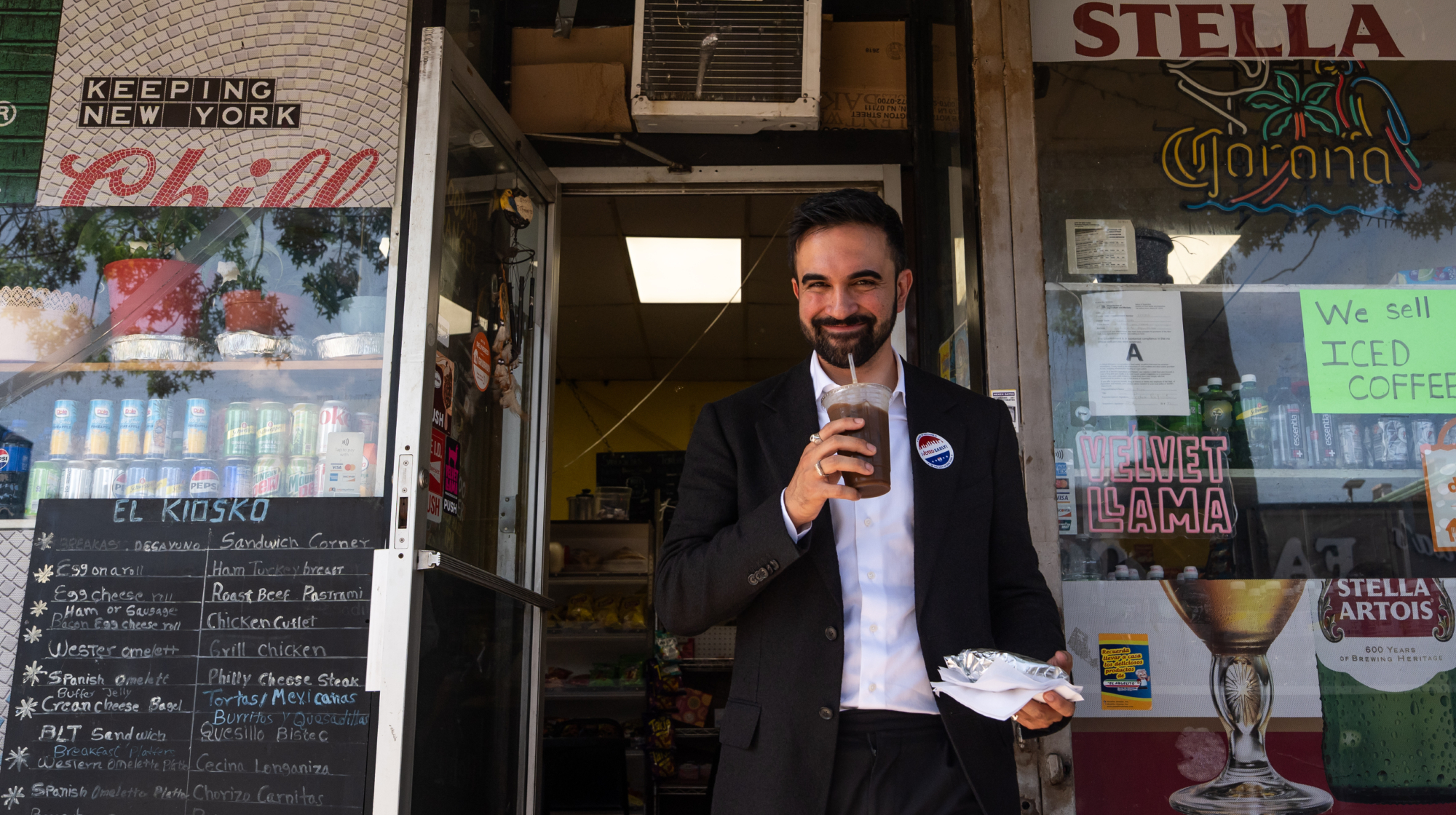 Zohran Mamdani, New York City mayoral candidate, walks out of a deli with an iced coffee after a campaign event in the Queens borough of New York, US, on Thursday, June 19, 2025. The mayoral race has become one of the most crowded in recent memory, with at least nine Democrats with significant fundraising numbers running in this month's primary. 