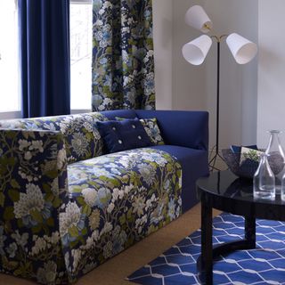 living room with blue florals sofa and curtain