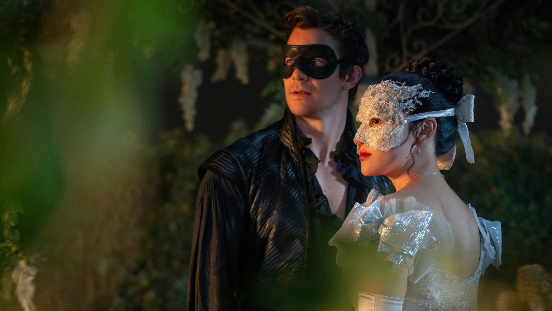A masked Benedict and Sophie stand in a garden