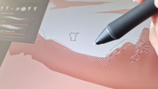 A close up of a stylus drawing on a tablet screen