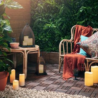 Almeida Moroccan Candle Lantern Duo from Lights4fu in an outdoor terrace area, with wooden furniture including a sofa and side table