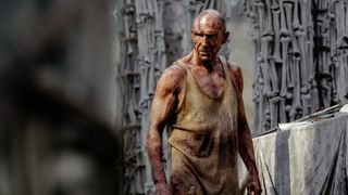 Doctor Ian Kelson standing upright in a place surrounded by bone columns in 28 Years Later