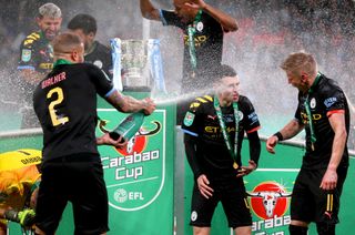 Manchester City’s Kyle Walker, left, sprays Alexander Zinchenko, right, and Phil Foden with Champagne