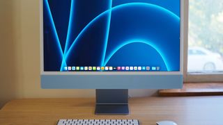 A 24-inch iMac in blue on a table or desk