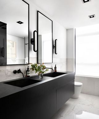 bathroom with black vanity and white marble floor