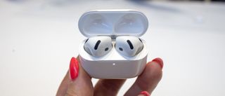 Apple AirPods 4 in their case in the hand