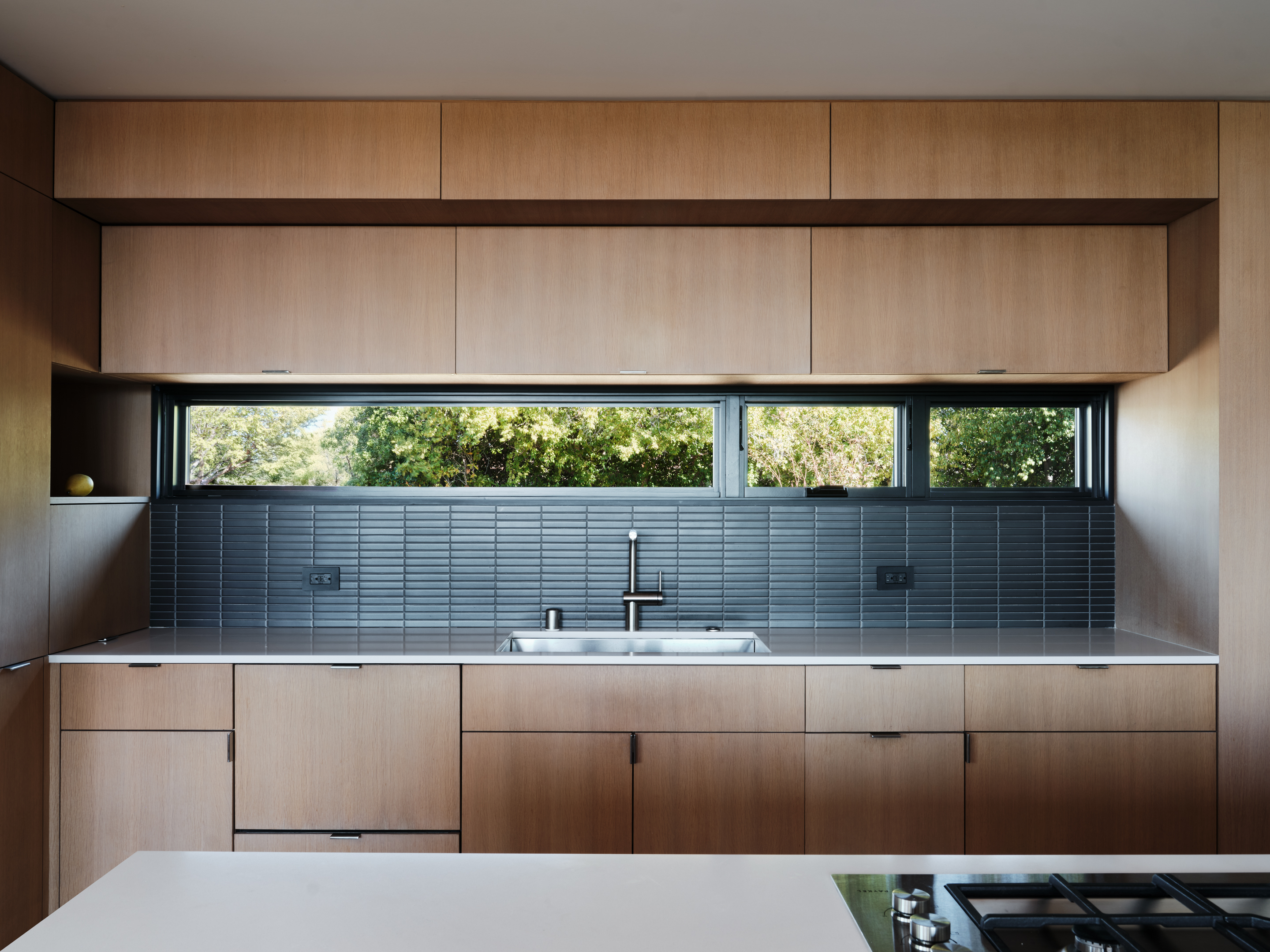 Hilltop Residence by Michael Hennessey Architecture, a modernist inspired home, low lying and linear with timber ceilings and black accents