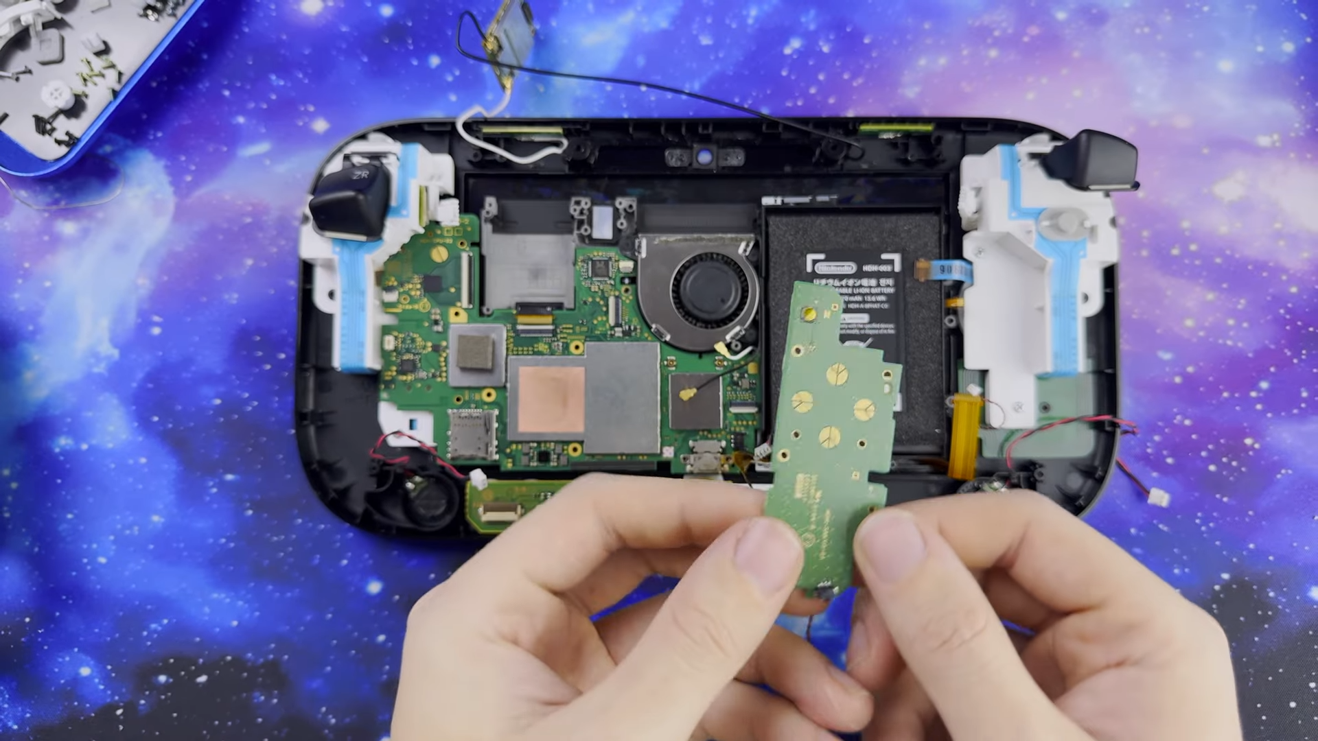 Switch Wii U Gamepad mod with cover off and hands holding button board in front.