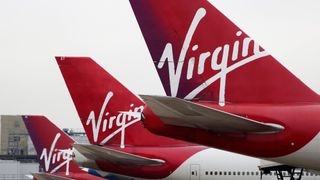 Three airplanes bearing the Virgin Atlantic logo on their tailfin.