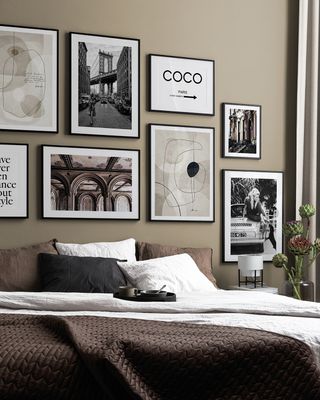 gallery wall of landmarks and logos in a neutral bedroom above the bed