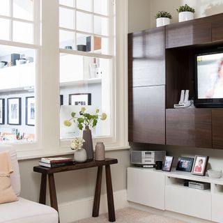living room with tv showcase and white window