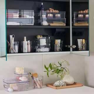 bathroom cabinet with clear storage containers neatly stacked