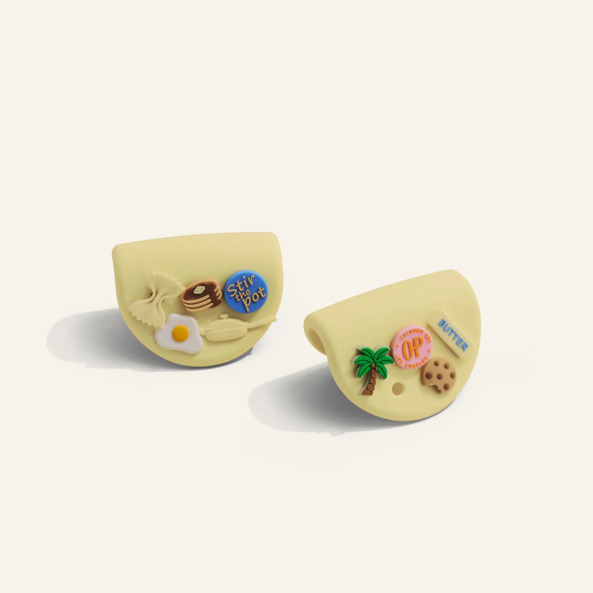 Butter yellow silicone pan handle grips with food-themed charms