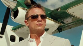 Daniel Craig wearing sunglasses in front of a plane in Casino Royale.