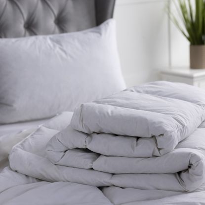 White duvet folded up on bed