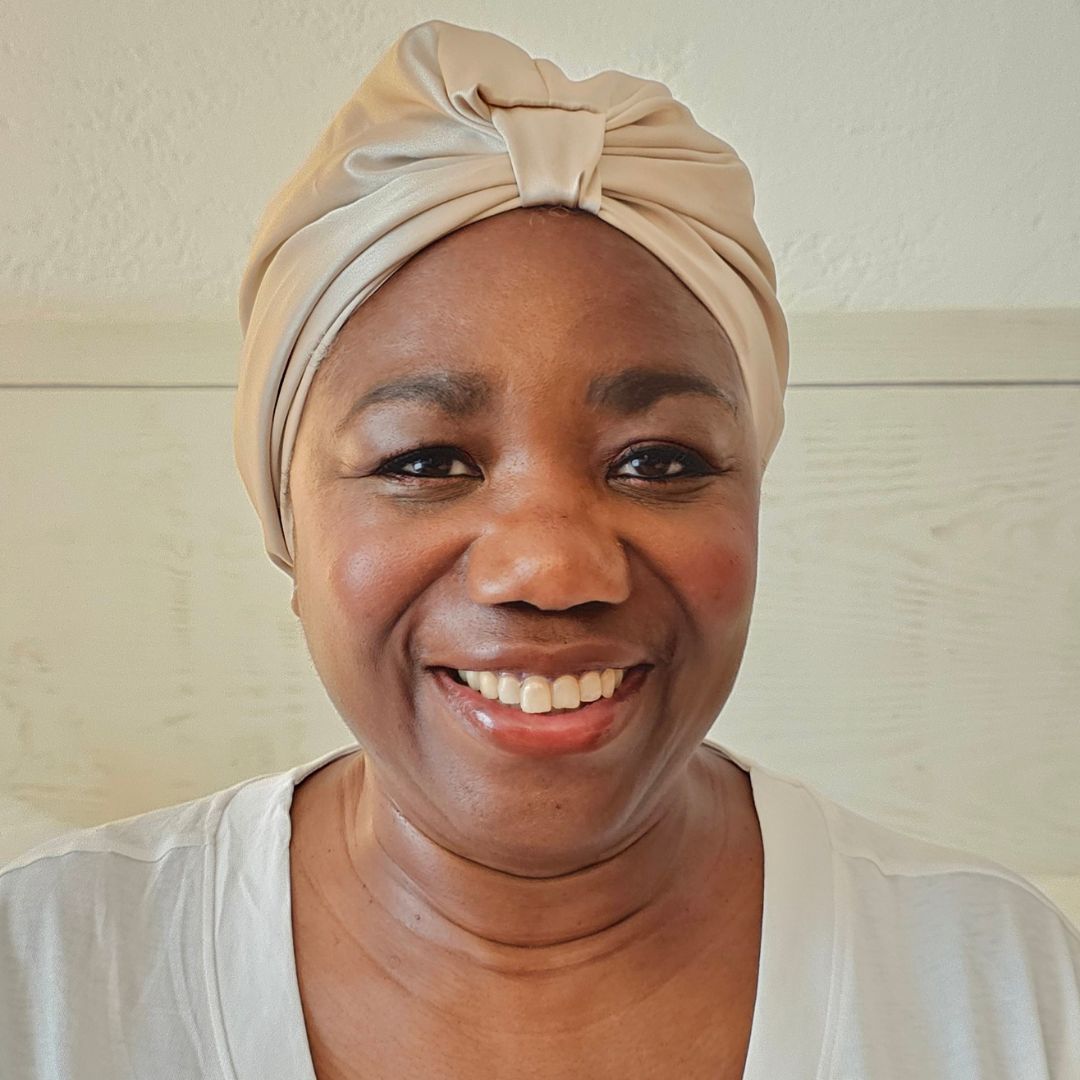 Joyce Connor pictured wearing the x silk hair wrap, tied around her hair and smiling to the camera