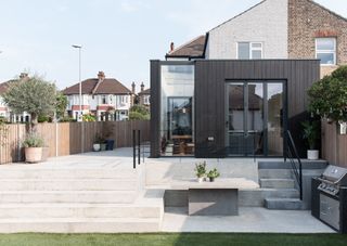 black timber clad wrap around extension to white semi detached house