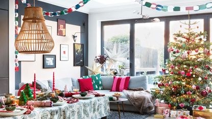 Blue living room with grey sofa and colourful christmas tree