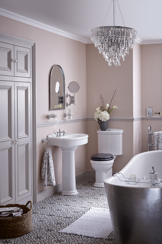 traditional elegant bathroom with patterned tiles and a metallic silver freestanding bath