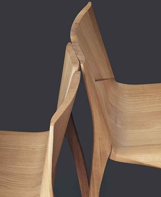 Two wooden chairs shown back to back designed by Zaha Hadid Design for Karimoku