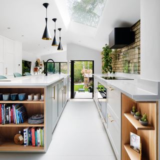 Shaker-style kitchen units in a kitchen extension with black pendant lights over island