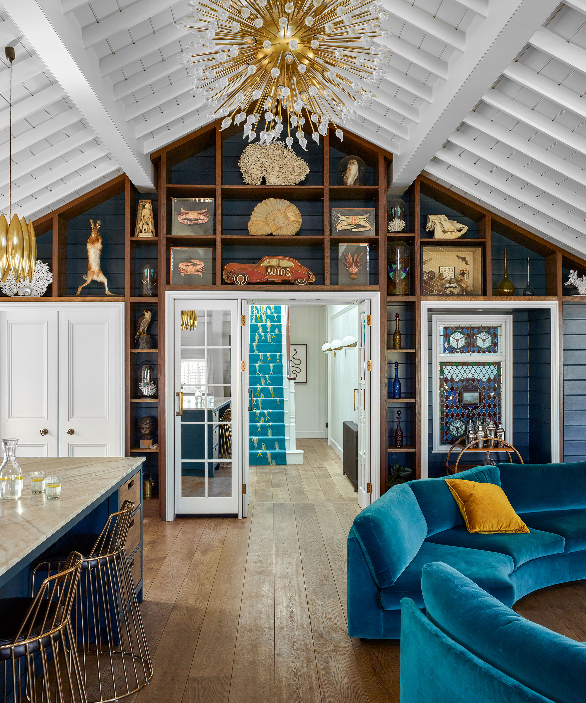 Open plan living room with high ceiling and blue velvet sofa