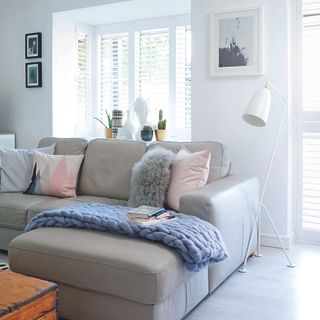 Living room with grey sofa, pink cushions and grey throw
