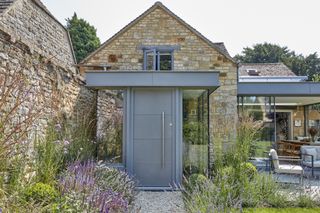 grey front door on glass porch extension to cottage