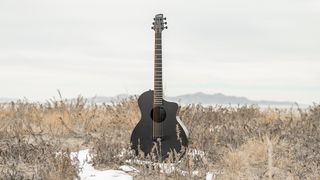 Klos Guitars Grand Cutaway Mini acoustic guitar in a snowy field