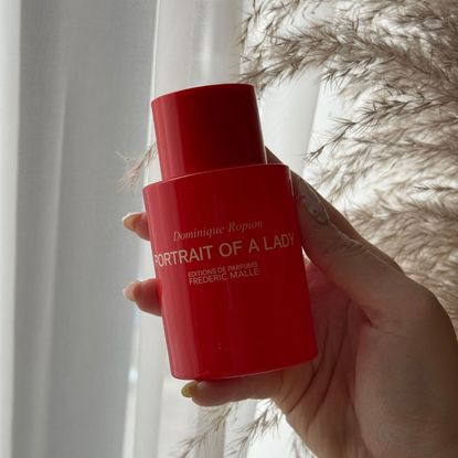 An image showing the Portrait Of A Lady perfume by Frederic Malle in a red bottle