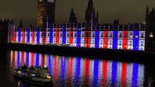 The Palace of Westminster alit in red, blue and white by Cameo lights.