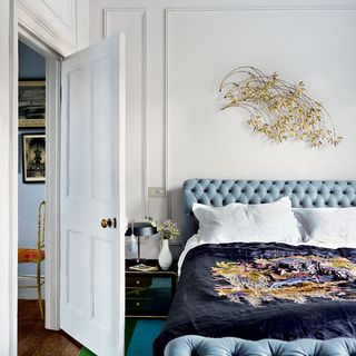 bedroom with willow branch artwork and chesterfield bed