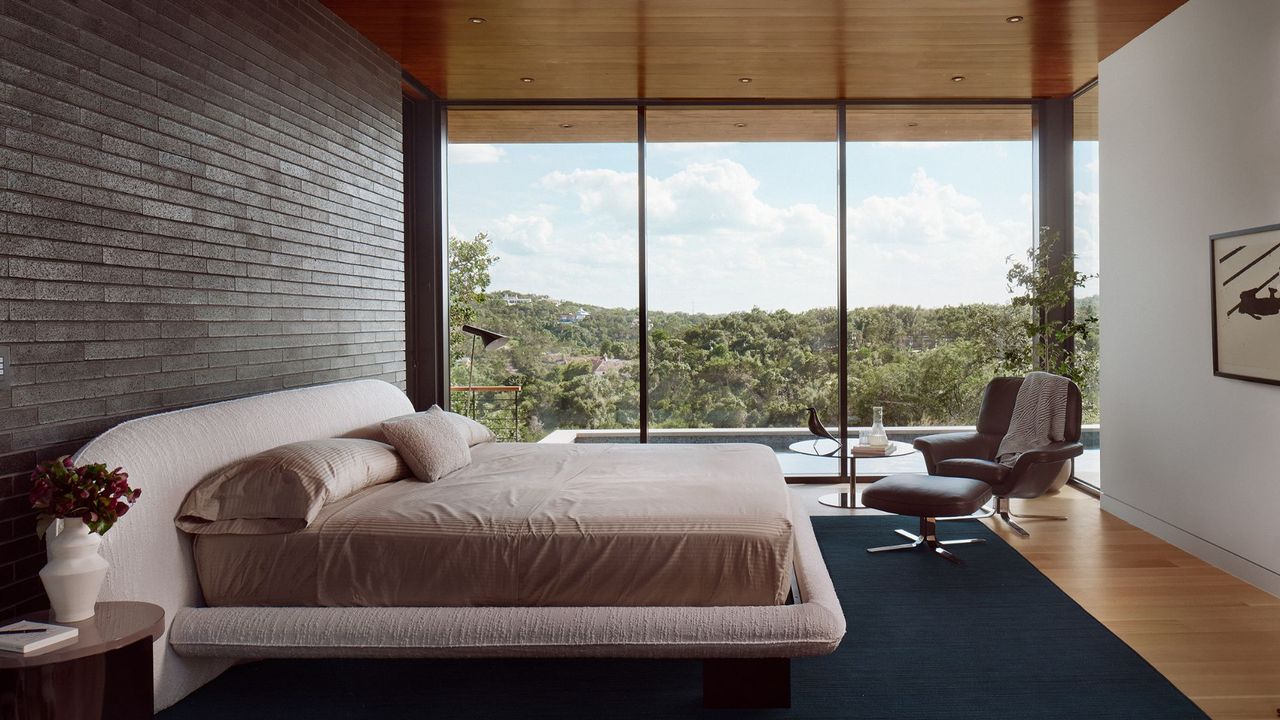 A bedroom with large ceiling to floor windows