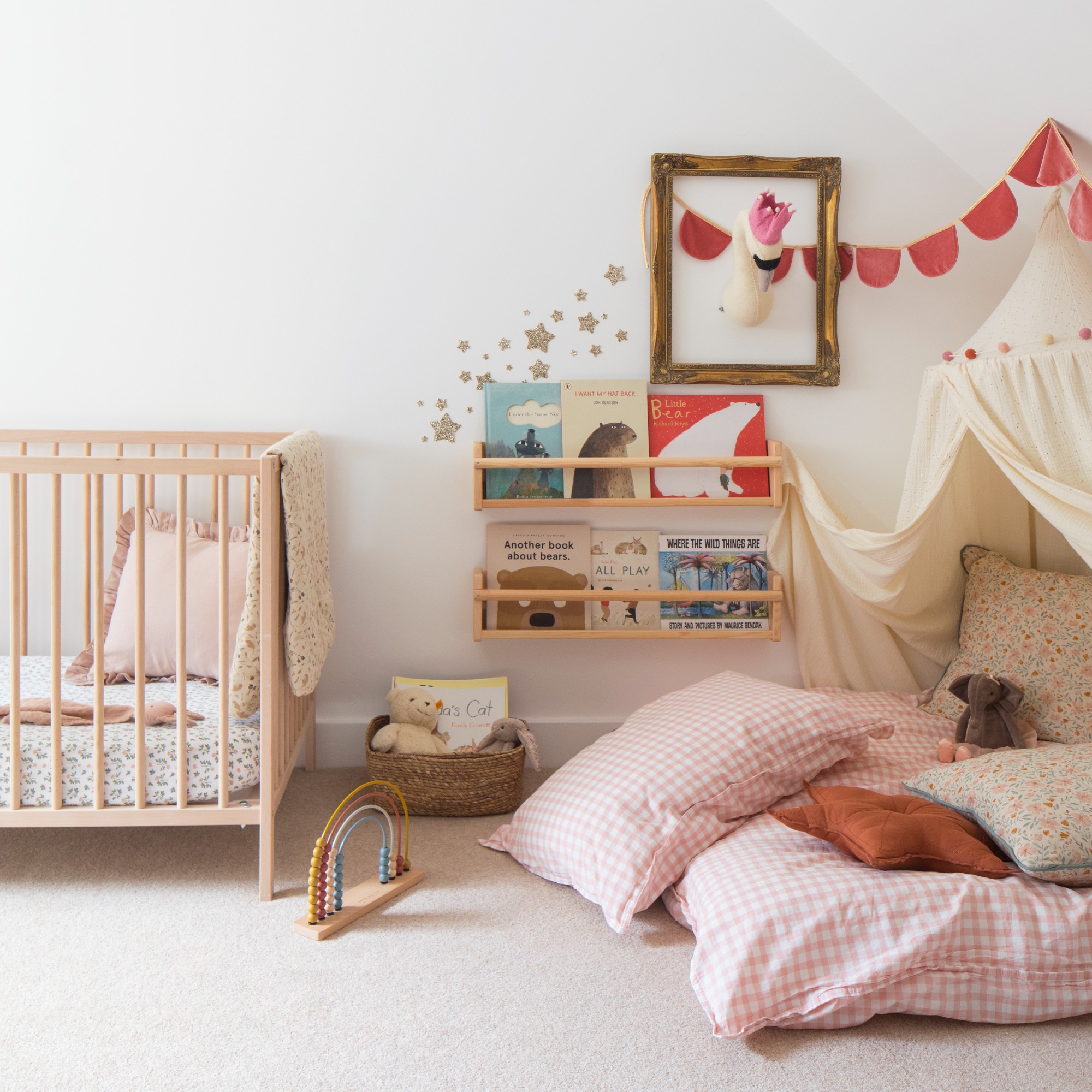 A nursery with a reading nook with a canopy and shelves storing books