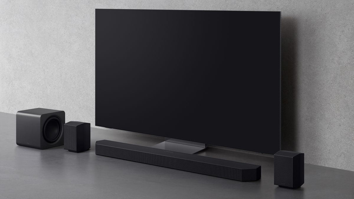 Samsung HW-Q990F soundbar package on a grey backdrop sitting below a TV